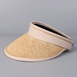 Détail de la texture en raphia et bordure en tissu sur le chapeau visière