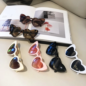 Flat lay of heart-shaped kids sunglasses in six assorted colors with UV400 protection