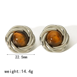Détail macro de boucles d'oreilles spirales de 22,5 mm avec pierres œil de tigre ambrées