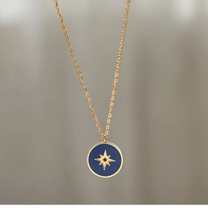 Detailed close-up of 18K gold-plated compass pendant with blue enamel and star