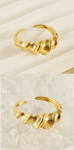 Macro detail of the golden twisted spiral texture and adjustable open band on the ring