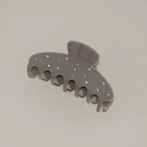 Detailed view of the dark grey resin hair claw clip with sparkling white rhinestones