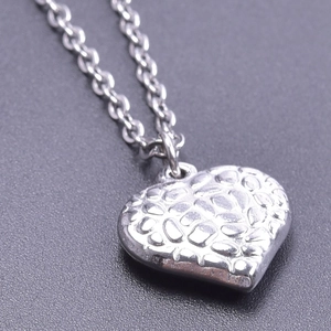 Macro shot of silver heart pendant featuring textured 3D irregular surface design