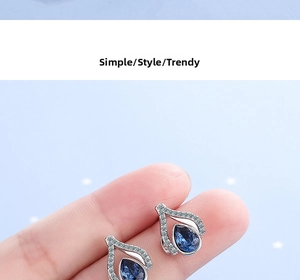 Macro close-up of blue teardrop crystal earrings with silver metal and white zircon
