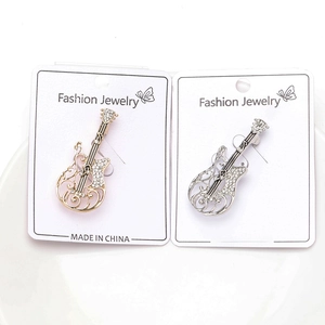 Detail of guitar brooches in gold and silver finish with sparkling rhinestone accents