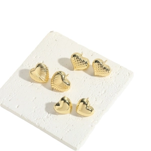 Three pairs of heart-shaped gold stud earrings in smooth, striped, and quilted designs