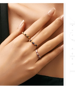 Detail of stacked vintage silver rings with moonstone and red gems on a model hand