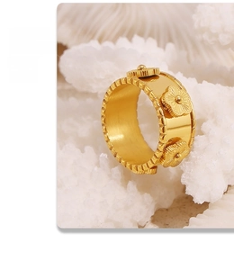 Dettaglio macro di anello a fiori dorati con tre petali su corallo bianco