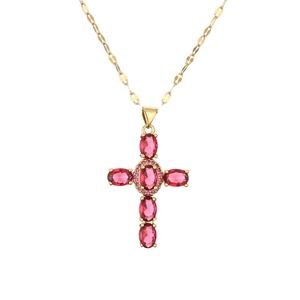 Gold cross necklace with pink oval gemstones and flat link chain on white background