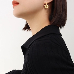 French vintage style gold-plated titanium steel flower earrings shown on a model's ear
