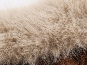 Dettaglio ravvicinato della morbida pelliccia beige sul colletto del maglione invernale