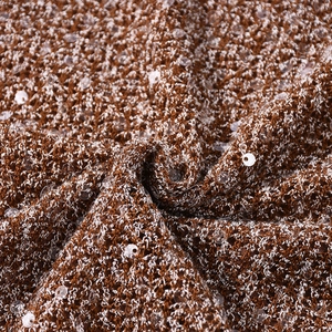 Vue macro du tissu en maille marron à paillettes montrant la texture et les reflets