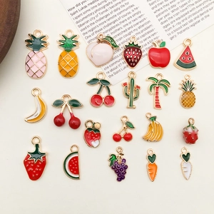 Macro view of assorted fruit enamel pendants for DIY jewelry making on white surface
