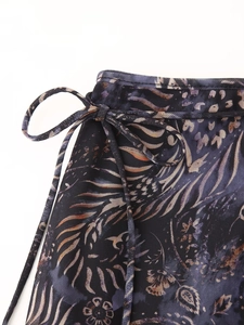 Détail du nœud papillon latéral sur la jupe en tulle aux motifs dorés et violets