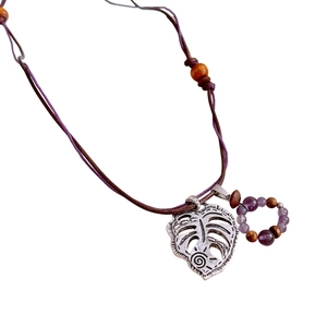Bohemian style necklace featuring a vintage silver leaf pendant and purple wood beads
