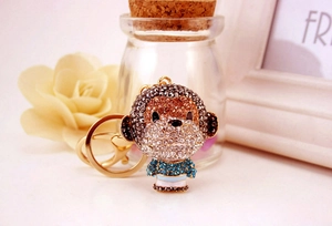 Detailed view of monkey keychain adorned with brown and blue rhinestones on gold metal
