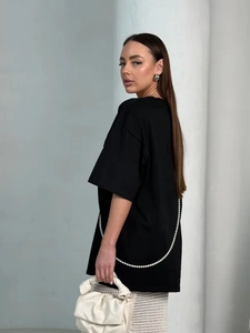 Detail of oversized black cotton T-shirt featuring a chic pearl chain decoration on the back