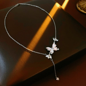 Vue détaillée d'un pendentif papillon avec ailes en nacre et pampille en zircon de coeur