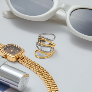 Detail of two-tone wave ring with interlocking gold and silver metallic curved bands