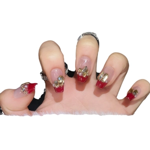 Handmade red wine French press-on nails with gold metal accents and rhinestone details