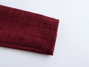 Nahaufnahme der dunkelroten Tweed-Textur und gewebtes Manschettendetail am Kleid