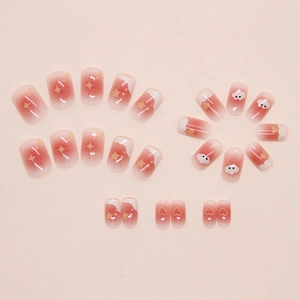 Detailed flat lay of 24 cute pink gradient press-on nails with stars and cloud patterns