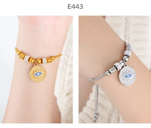 Detail view of evil eye bracelet with blue enamel and sliding clasp closure in gold and silver
