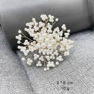 Close-up of elegant pearl snowflake brooch with golden wire and 8x8 cm size detail