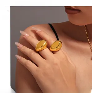Macro view of polished 18K gold-plated irregular teardrop rings with mirror finish