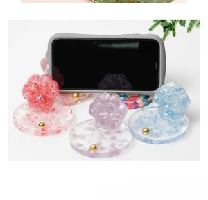Cat paw crystal resin phone stands in pink and blue with decorative glitter flakes