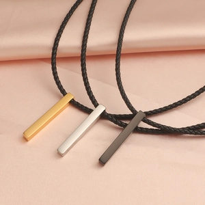 Three rectangular bar pendant necklaces in gold, silver and black on pink silk fabric