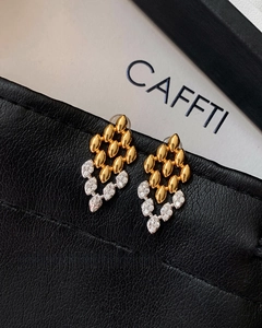 Vue macro de boucles d'oreilles grain d'or avec zircons pavés et texture en métal
