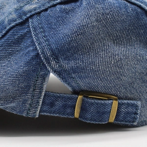 Vista posteriore del berretto in denim lavato con fibbia in metallo regolabile e trama a saia