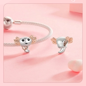 Macro view of S925 silver axolotl charm with rose gold accents on a bracelet