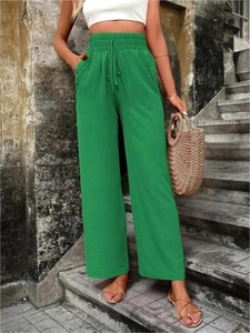 Détail du pantalon large vert à taille haute avec cordon et boutons latéraux