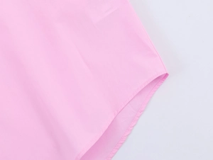 Detail of pink poplin shirt hemline with high-quality curved stitching and smooth texture