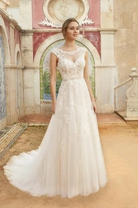 Close-up of floral lace embroidery and sheer illusion neckline on a white bridal gown