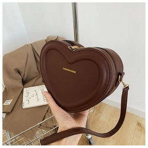 Dettaglio di una borsa a tracolla marrone a cuore con scritta logo dorata di moda