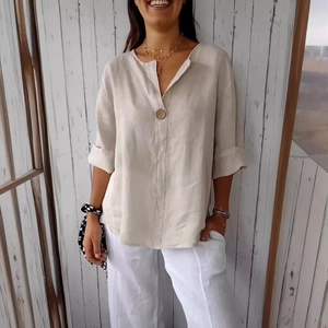 Detail of loose-fit V-neck cotton linen shirt with button and rolled sleeves texture