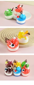 Detailed close-up of assorted artificial dessert cups with cream and fruit toppings