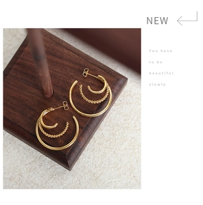 Detail of 18K gold-plated triple-layer hoop earrings with elegant twisted rope texture