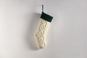 Detailed close-up of knitted Christmas stocking with cable pattern and hanging loop