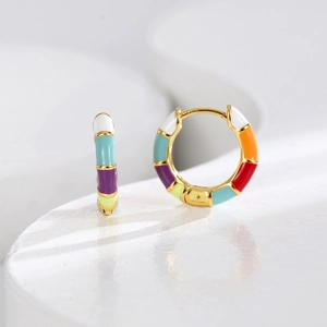 Chic bamboo-style gold earrings with colorful rainbow enamel blocks on a white surface