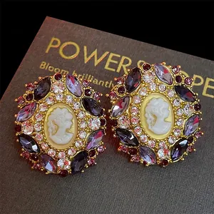 Vintage style gold cameo earrings with purple and red crystals in a Victorian design