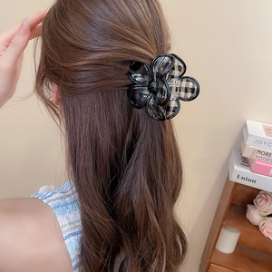Detail of floral claw clip with black and white grid fabric on a woman's hair