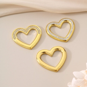Detailed view of polished gold heart pendants with rhinestone accents on soft fabric