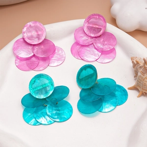 Detail of layered round shell-style earrings in pink and turquoise for summer beach style