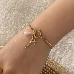 Bracciale dorato con ciondoli, perle, stelle e cristalli su catena a maglie miste
