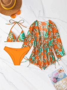 Flat lay of orange three-piece bikini set with tropical leaf print and drawstring mesh cover-up