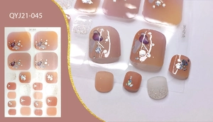 Close-up of nude peach gradient toe nail stickers with silver glitter and purple patterns
